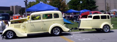 [Creme colored car trailer shaped like the car including having windows.]